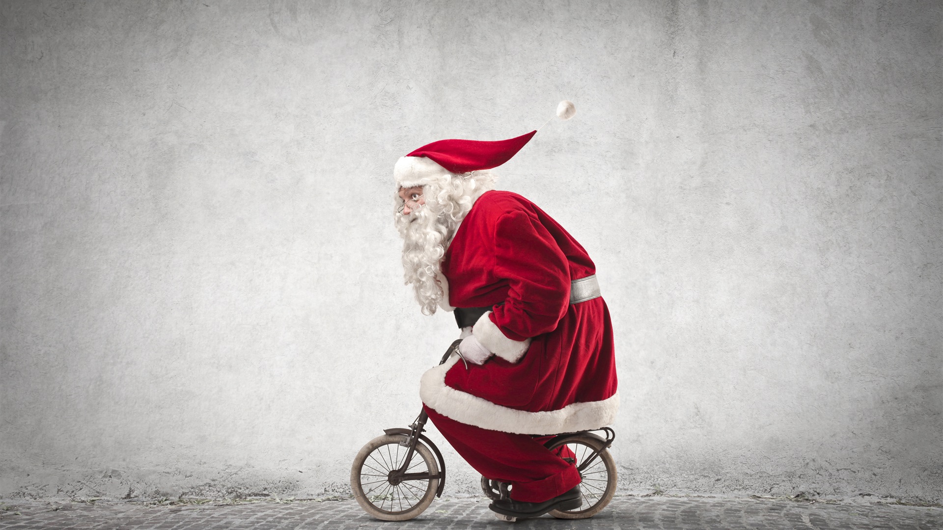 Santa-Claus-riding-a-small-bike-humor-red-coat-glasses-Christmas-theme_1920x1080.jpg