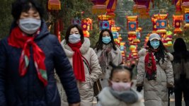 Chinese wear masks as they walk under decorations in a park after celebrations for the Chinese...jpg